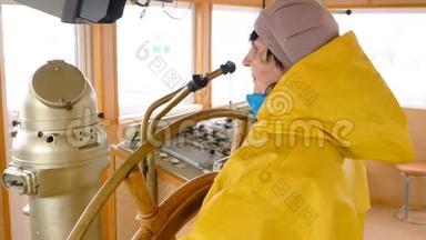 穿着黄色雨衣的老妇人控制着<strong>掌舵</strong>的船。